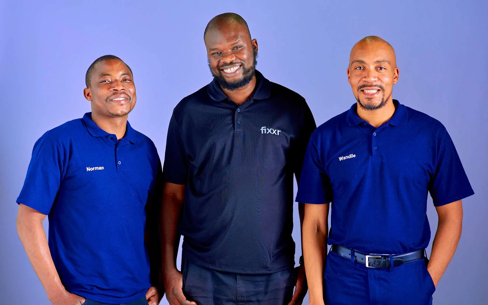3 Fixxr mechanics standing side by side smiling in Fixxr golf shirts