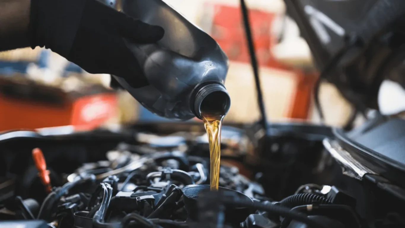 Car engine oil being poured into engine